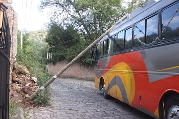 Cae poste de Telmex sobre autobús de turistas